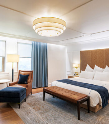 kraemer-design-group-kdg-detroit-athletic-guestroom-renovation-interior-hotel-blue-ottoman-leather-chair-terracotta-modern-bedroom-header