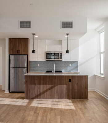 kraemer-design-group-kdg-detroit-free-press-building-interior-kitchen-teal-backsplash-walnut-cabinets-white-acrylic-cabinet-counter-blue-accent-wall-header