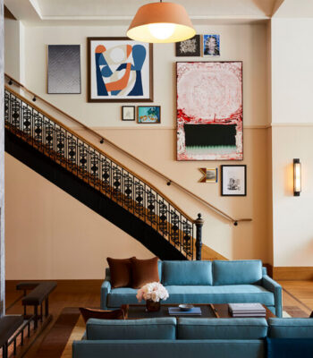 kraemer-design-group-kdg-shinola-hotel-interior-lobby-area-fireplace-blue-couch-staircase-art-color-mirror-header